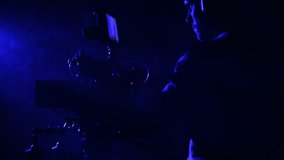 Dark Blue Illuminated Place with Some Smoke Around. Digital Camera with Caucasian Operator Film Making Theme