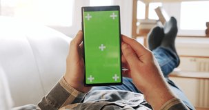POV view of Man at Home Lying on a Couch using Smartphone with Green Mock up with markers on Screen, Version 1