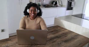 Happy african girl talking on a video call using computer laptop at home 