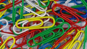 Stop motion animation. Multicolor paper clips animated background. Office concept