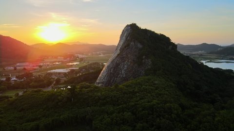 4k Wide pan around Buddha Mountain in Pattaya at stunning Sunrise. Drone shot: image of Buddha engraved with gold into the hill in Khao Chi Chan, Chonburi, Thailand. Cinematic thai attractions.