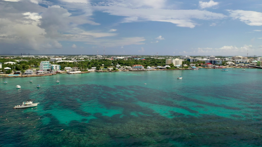 Drone shot over the ocean moving towards small Cayman Islands town Royalty-Free Stock Footage #1069135927