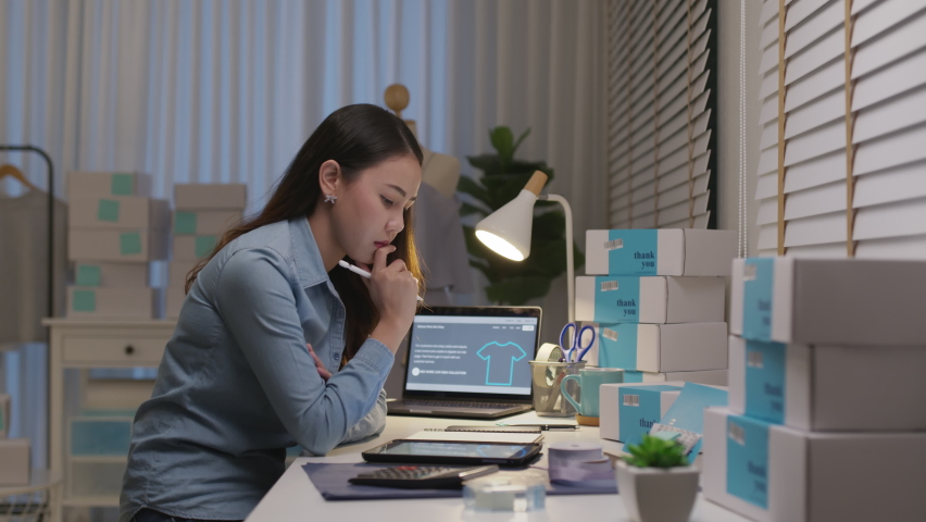 Young attractive asia female business owner thoughtful serious doubtful feel stress worry with financial problem in SME crisis small business challenges impact from covid coronavirus at home office. Royalty-Free Stock Footage #1069139653