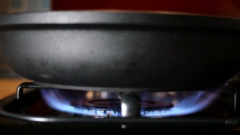 Process of burning and appearing blue flame gas methane or propane on kitchen gas stove. Kitchen burner switching. Natural gas inflammation. Selective focus. Close-up.