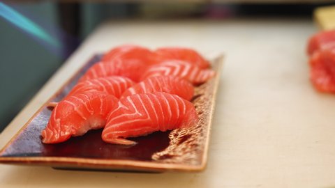 Extreme close up shot of raw salmon sushi on a plate burning before serve in Japanese food restaurants.