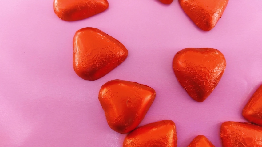 Chocolate candies shape of hearts on pink background