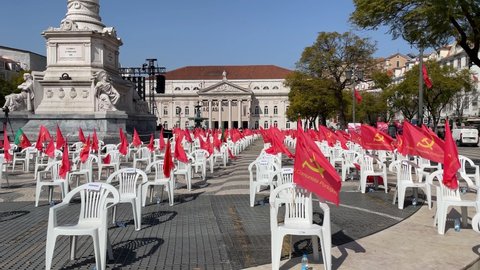 Communist Flags Waving On Public Square, Communism Party Protest Panning Shot. LISBON, PORTUGAL - 06 MARS 2021; Portuguese communist party protest in Lisbon waving many flags on a public square.