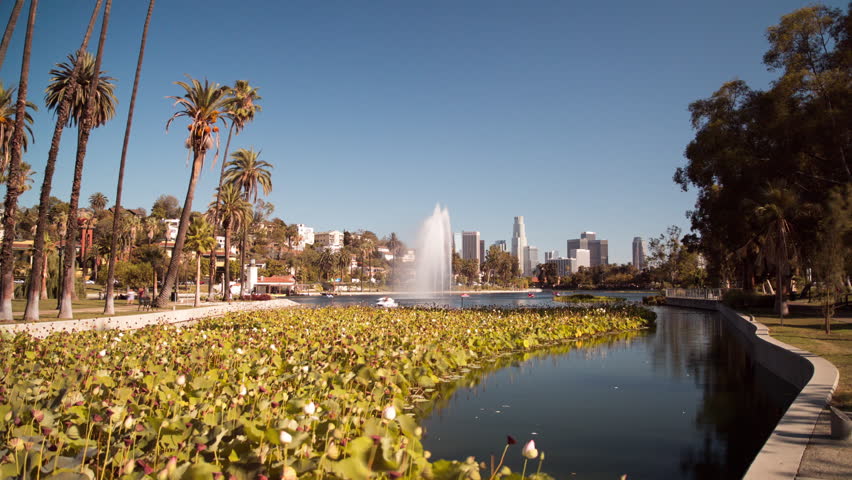 Hyperlapse of Echo Park Lake, Los Angeles, California during the day.  Fountain in lake, people on pedal boats going by, views of Downtown Los Angeles.  US Bank Tower, Bank Of America Center in shot.