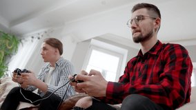 Side view of nervous young man losing in video game and leaving blurred friend at background. Sad angry guy throwing game controller and walking away. Losing and gaming concept.