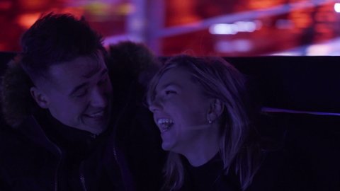 CU Couple laughing on amusement park ride at night, Belfast, Northern Ireland, UK
