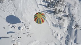 AERIAL: landing of a paraglider with a passenger on a ski slope, next to a large beautiful balloon. snow-covered forest on a sunny day. 4k Prores 422 - Powered by Shutterstock - Get 15% off with code: PIKWIZARD15