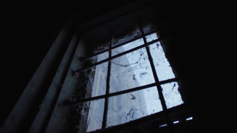 View of the Sky through the Barred Window with the Web in the Old Cellar of the Abandoned Prison