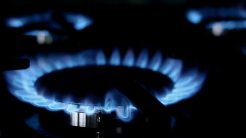 Process of burning and appearing blue flame of gas methane or propane on kitchen gas stove. Kitchen burner switching. Natural gas inflammation. Selective focus.