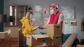 Moving to new flat or office. Customer paying to delivery man using NFC technology with phone and credit card, giving receipt back, contactless payment with student girl to a professional mover.   - Powered by Shutterstock - Get 15% off with code: PIKWIZARD15