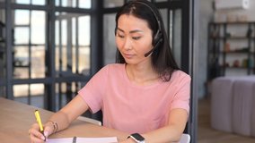 Female hr with headset sitting at desk at home, talk on video call, interviewing for the position, organizes an event for the company, works online, woman have pleasant webcam conference