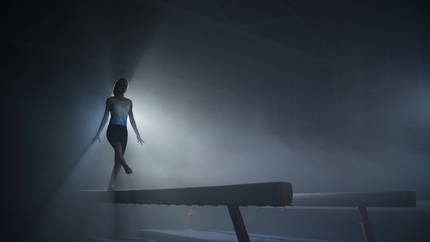 graceful young female gymnast is performing on balance beam, training in sport school, youth and sport activities, slow motion shot Royalty-Free Stock Footage #1069175248