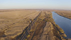Drone video along the river and railway, surrounded by fields