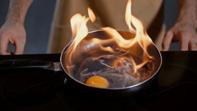 cropped view of man frying egg with flame method