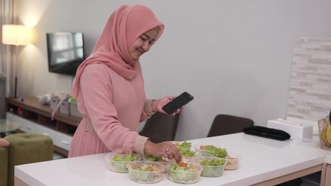 muslim asian woman home catering service preparing lunch box for takeaway food online order