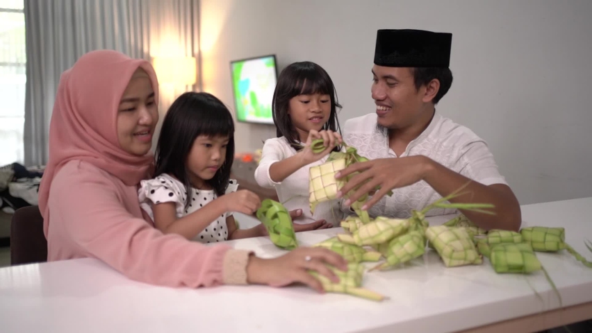 Happy asian muslim family making ketupat together at home before eid mubarak | Shutterstock HD Video #1069185949