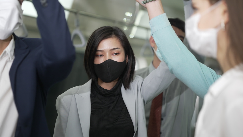 Tired freelance woman on crowded subway at rush hour. Woman wear mask protective go back home on rash hour after work in crowded subway. Royalty-Free Stock Footage #1069187377