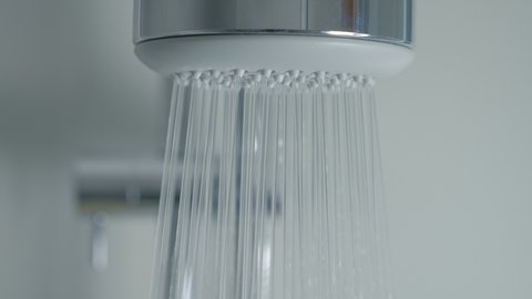Close-up of water drops in the shower head. Turn on shower head in bathroom.