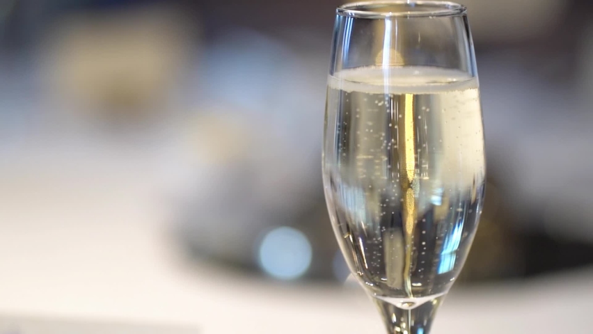 Close Up And Shallow Depth of Field of Champagne Bubbles In A Champagne Glass At An Event