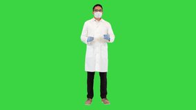 Wide shot. Front view. Doctor draws up syringe with COVID-19 vaccine on a Green Screen, Chroma Key. Professional shot in 4K resolution. 070. You can use it e.g. in your medical, commercial video, 