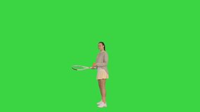 Wide shot. Front view. Young woman bouncing a ball on her tennis racket on a Green Screen, Chroma Key. Professional shot in 4K resolution. 068. You can use it e.g. in your medical, commercial video,
