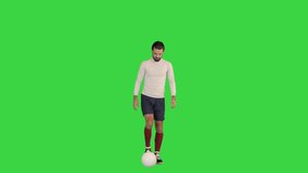 Wide shot. Front view. Football player bounces the ball on a Green Screen, Chroma Key. Professional shot in 4K resolution. 068. You can use it e.g. in your medical, commercial video, business, presen