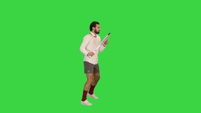 Wide shot. Side view. Young man imitating tennis game on a Green Screen, Chroma Key. Professional shot in 4K resolution. 068. You can use it e.g. in your medical, commercial video, business, presenta