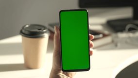 Handheld Camera. Point of View of Woman at Modern Room Sitting on a Chair Using Phone With Green Mock-up Screen Chroma Key Surfing Internet Watching Content Videos Blogs Tapping on Center Screen.