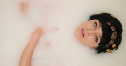 woman lies in a bath. woman takes milk bath.