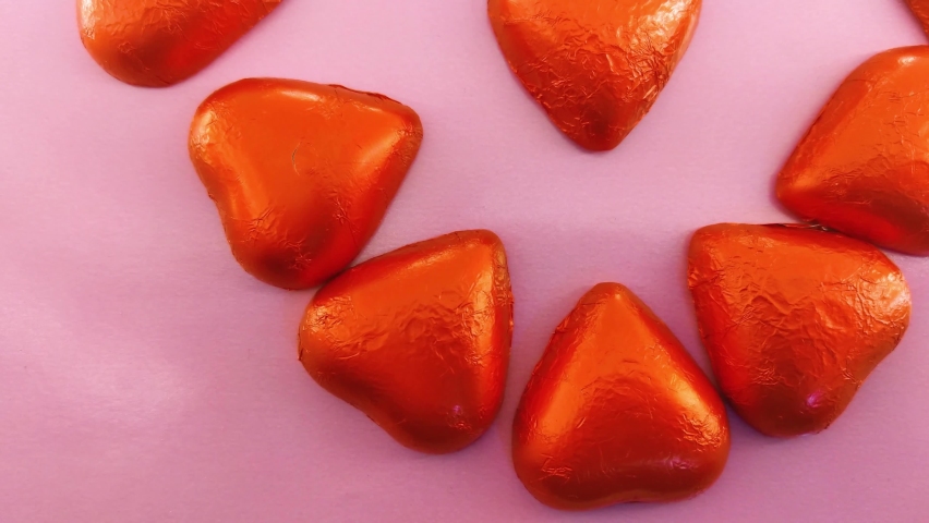 Chocolate candies shape of hearts on pink background