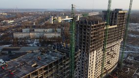 Aerial video of construction site with green construction cranes in winter at Kyiv