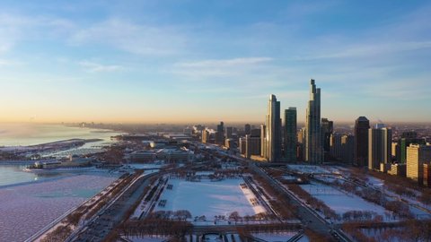 Chicago Loop, Frozen Lake Michigan and Skyscrapers of Near South Side District at Sunrise. Golden Hour. Frosty Winter. Aerial View. United States of America. Drone Flies Forward
