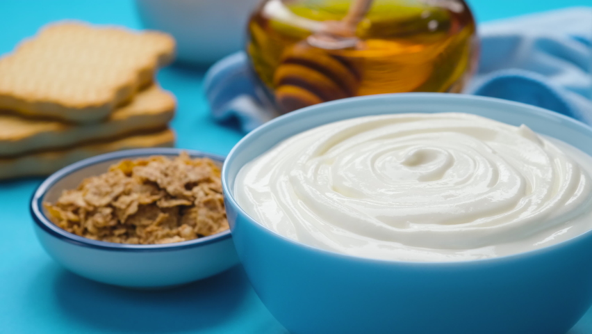 Bowl of sour cream on blue background, greek yogurt | Shutterstock HD Video #1069213711