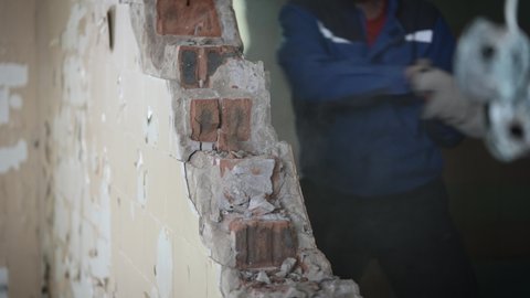 Dismantling an unnecessary brick wall during construction work in an old building.