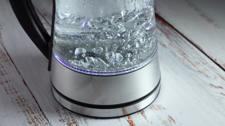 Water Boils in the Kettle on a Wooden Table. Slow Motion