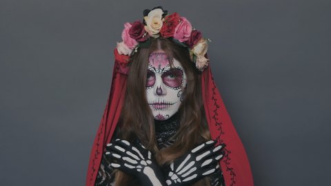 portrait of a girl with Halloween makeup, sugar mexican skull on a gray background