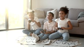 Happy african american kids playing video game with joystick at home