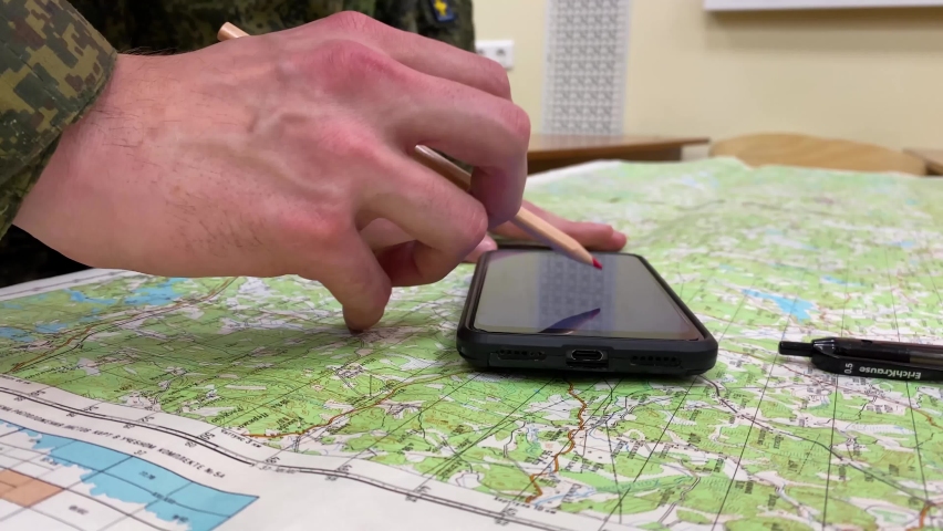 the soldier moves the phone and discusses the details