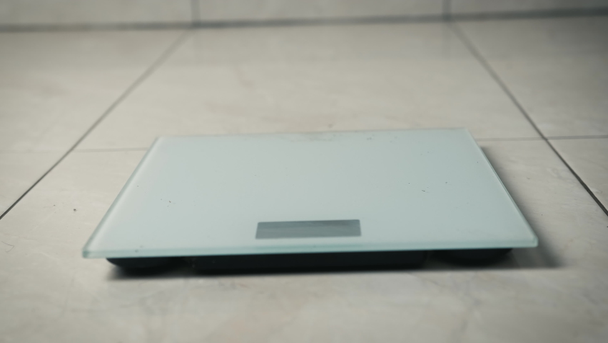 Close-up of legs getting on electronic weight and controlling their healthy sports life