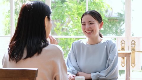 young japanese mother and daughter talking in the living room