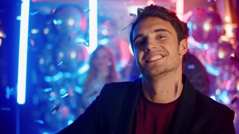 Portrait of charming man clubbing on neon lights background. Closeup attractive guy dancing at disco party in night club. Handsome man dancing in nightclub.