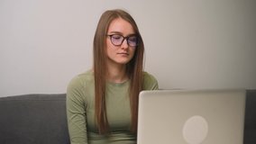 Focused young woman in glasses has video calling for remote job interview using laptop webcam conference work at home office. 