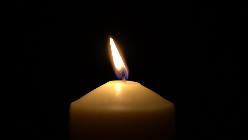 Single big yellow candle flame lights and extinguish, isolated on a black background. Slow motion, central framing close up. Royalty-Free Stock Footage #1069244170