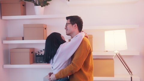 Young asian couple dancing and hugging in new apartment. Love and happy family concept. High quality 4k footage
