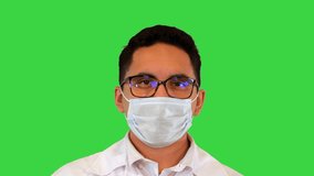 Close up. Doctor holds and looks at an ampoule of vaccine from covid-19 on a Green Screen, Chroma Key. Professional shot in 4K resolution. 070. You can use it e.g. in your medical, commercial video,