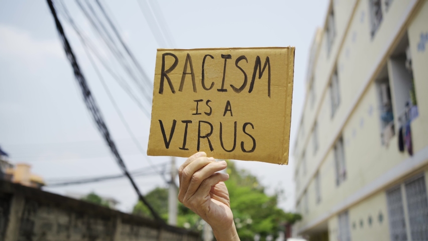 A man holding Racism is a Virus sign | Shutterstock HD Video #1069252351